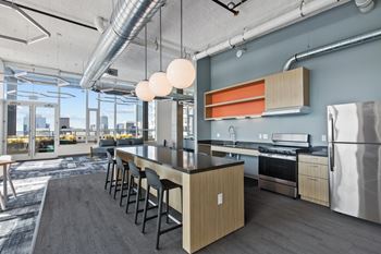 A modern kitchen with a long island and stainless steel appliances.
